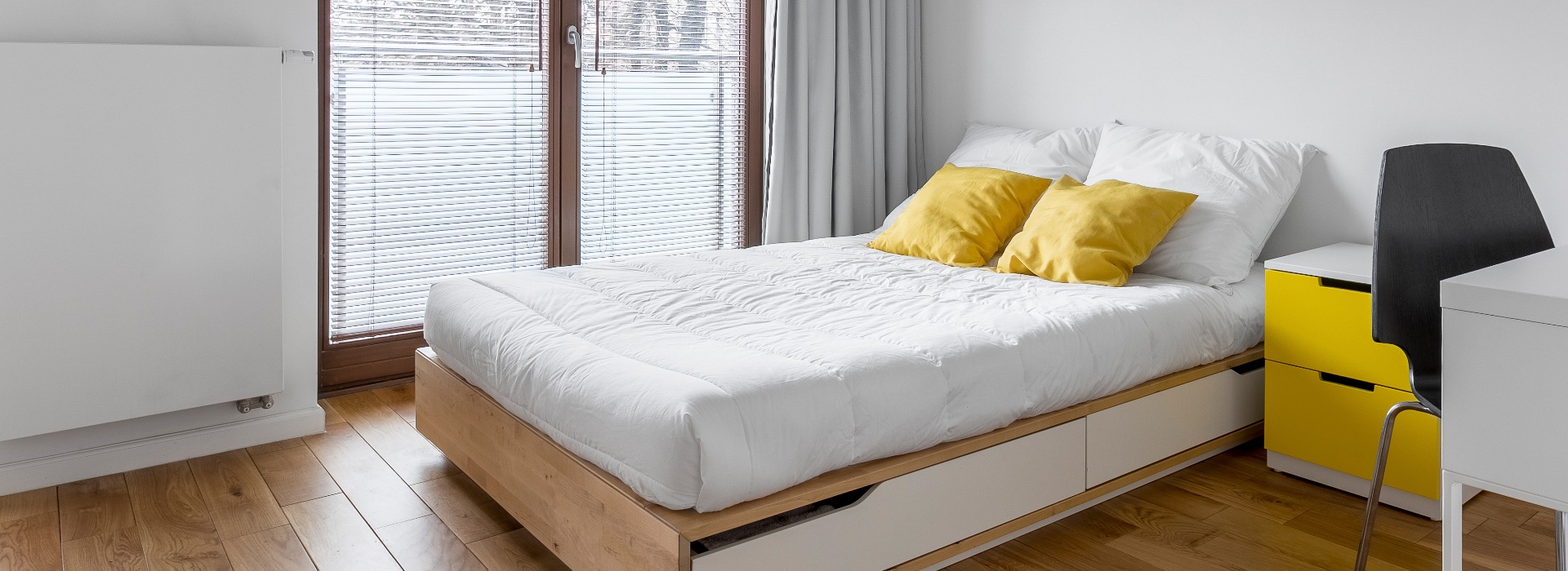 Weißes Schlafzimmer mit Bett und Schreibtisch